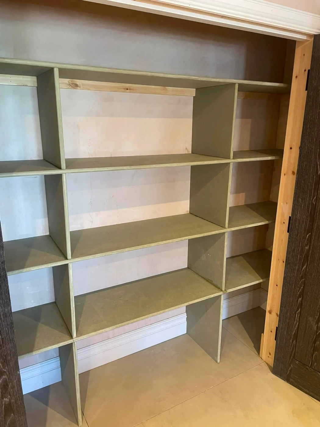 Custom fitted shelving with unpainted shelves and dividers